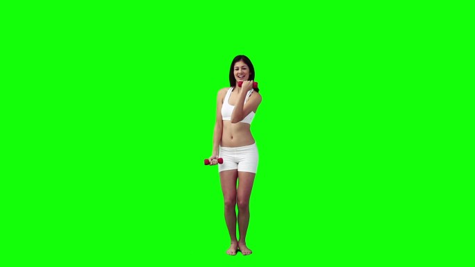 一个女人正在绿色的背景下用手练习重量