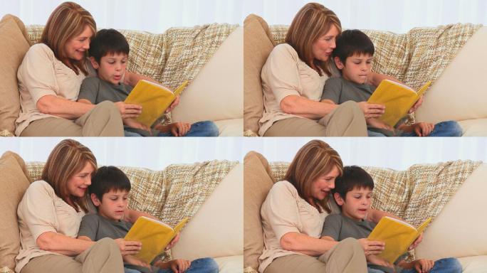 一位老奶奶在沙发上给她的孙子读书
