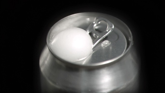 泡沫在黑色背景下以超慢动作从一个罐子里冒出来