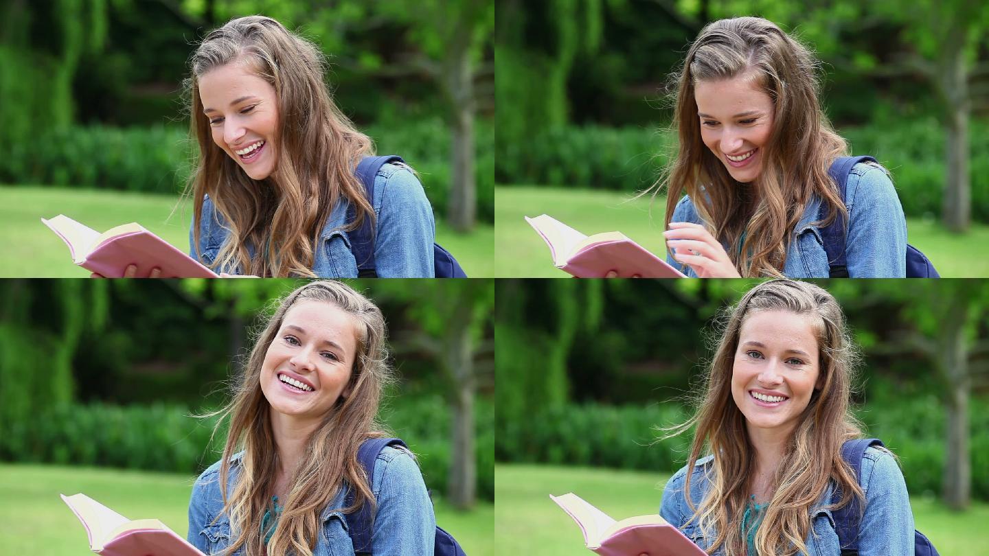 微笑的年轻女子在一个公园里看书