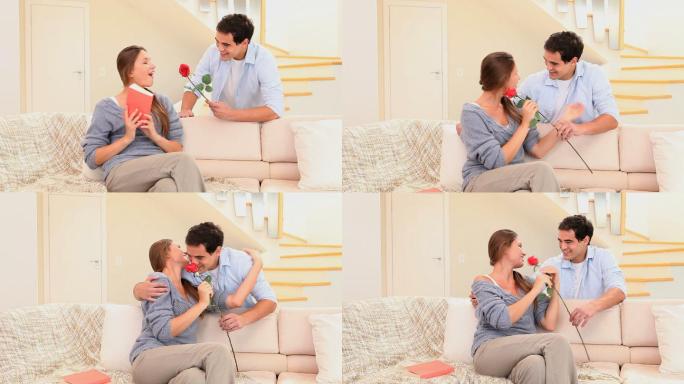 一名男子在客厅向未婚妻献上一朵红玫瑰