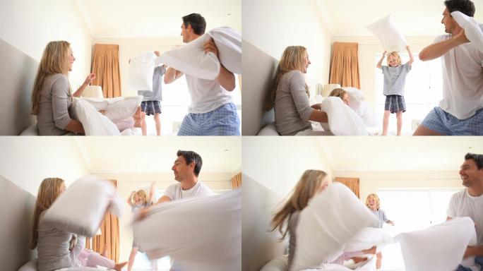 一个年轻的家庭在父母的房间里玩枕头大战