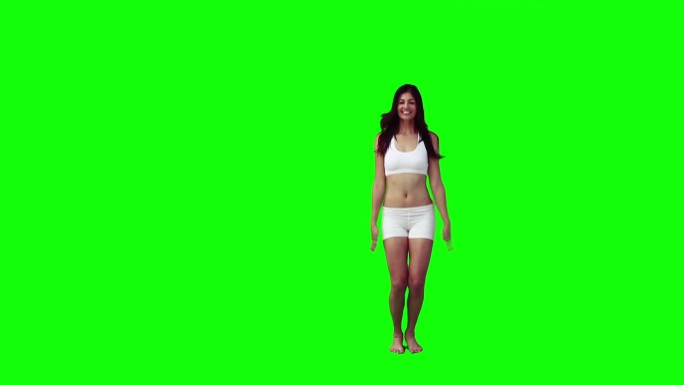 一个亚洲女性四肢伸展跳跃慢镜头，在绿色背景下