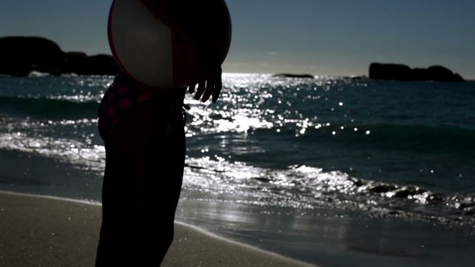 一个女人站在月光下的海滩上