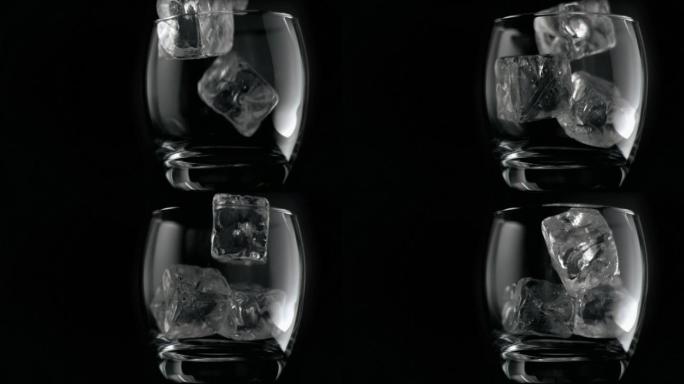 在黑色背景下，冰块以超慢的动作在玻璃杯中下落