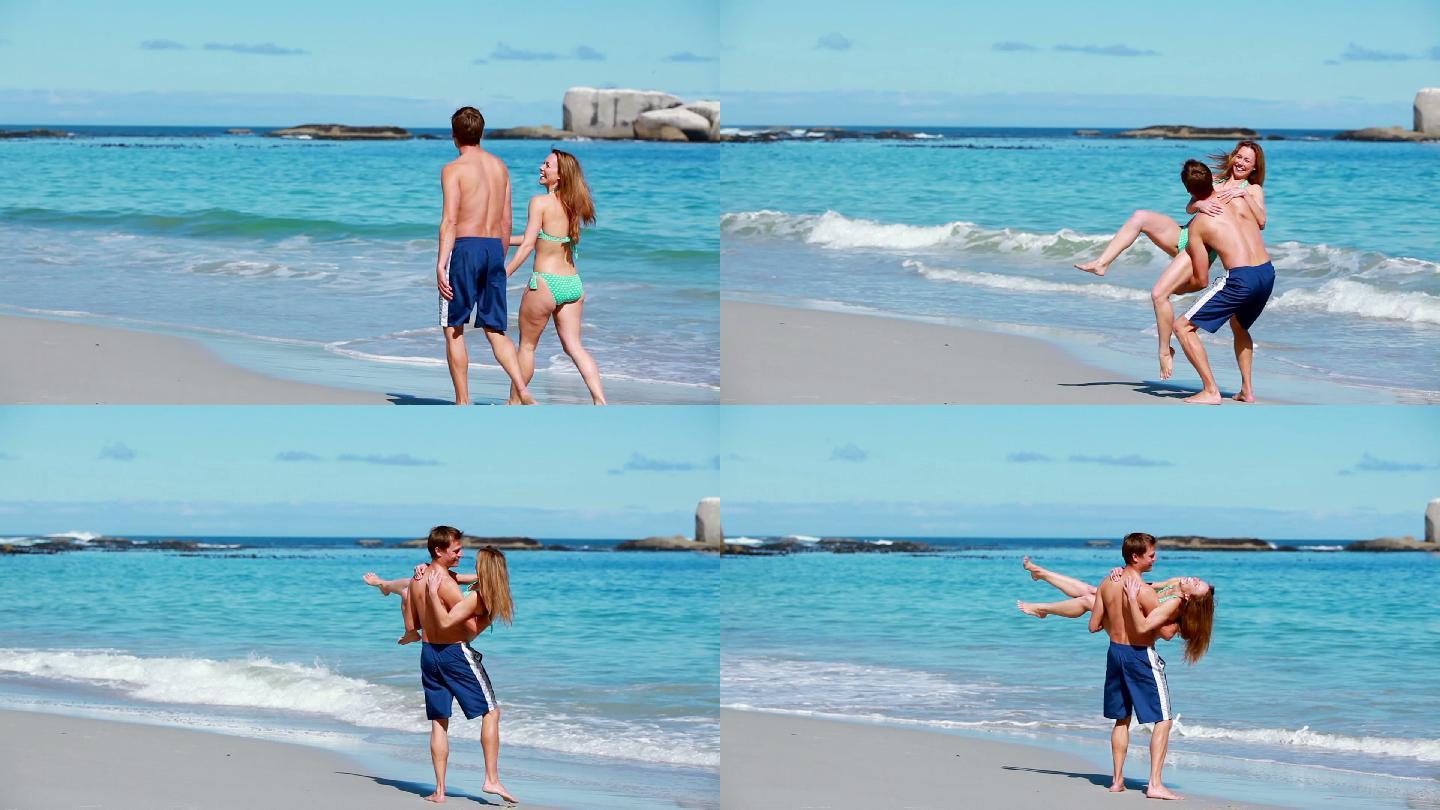 一个年轻人在海滩上抱着他的女朋友