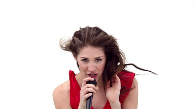 一个女人在唱歌，微风吹过她的头发，映衬着白色的背景
