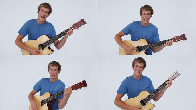 微笑的黑发男子弹奏着吉他，背景是白色