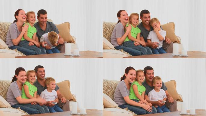 一家人微笑着在客厅看电影