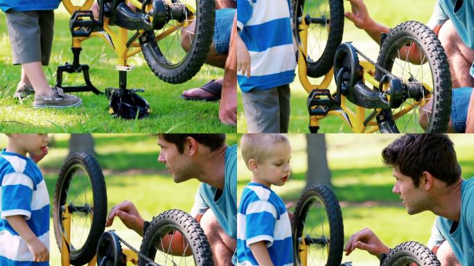 小男孩和他的爸爸在公园里玩他的自行车
