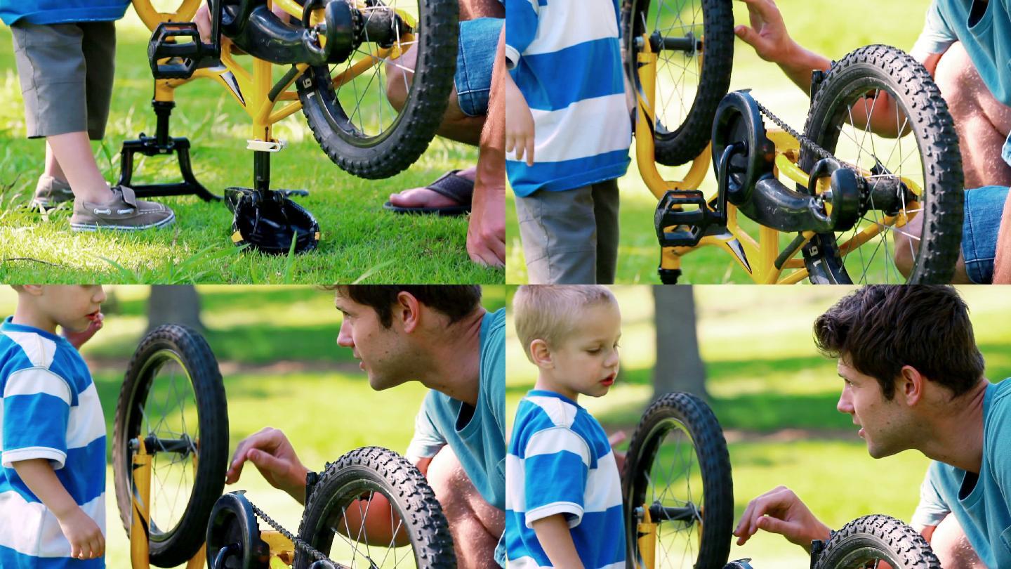 小男孩和他的爸爸在公园里玩他的自行车