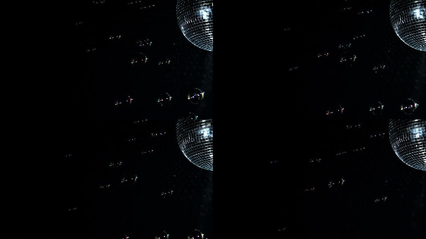 闪亮的迪斯科球旋转与浮动气泡在慢动作
