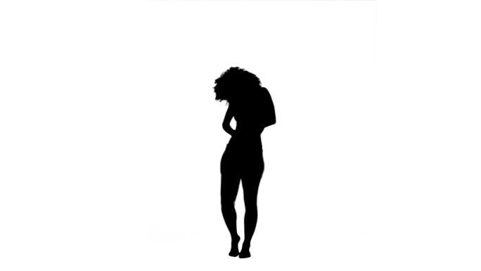 一个女人的剪影独自站在白色的背景下