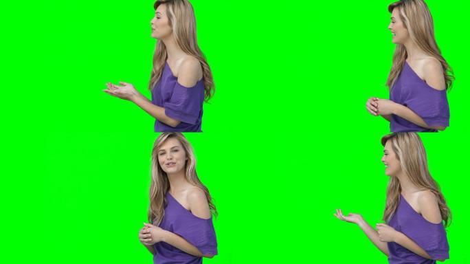一个女人在绿色背景下对着相机聊天