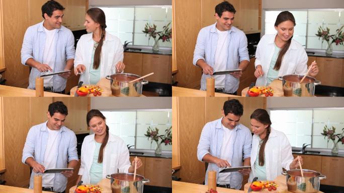 一对夫妇在厨房里用平板电脑做饭
