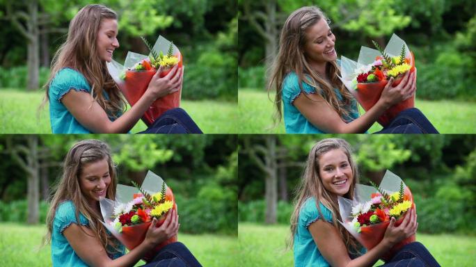一个兴高采烈的女人在公园里捧着一束花