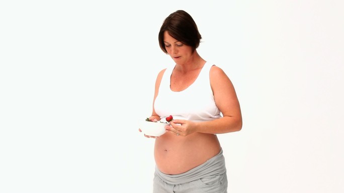孕妇吃草莓孤立在白色背景