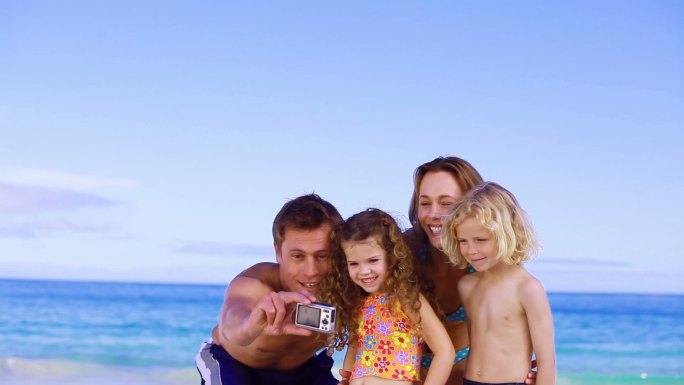 幸福的一家人在海滩上拍照