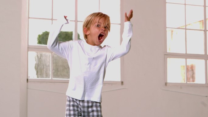 穿着睡衣的男孩在窗前跳来跳去大喊大叫的慢镜头