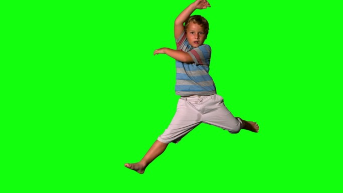 男孩跳在绿色屏幕上的慢动作