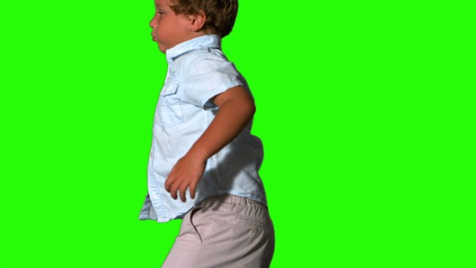 小男孩在绿色屏幕上跳来跳去，慢动作