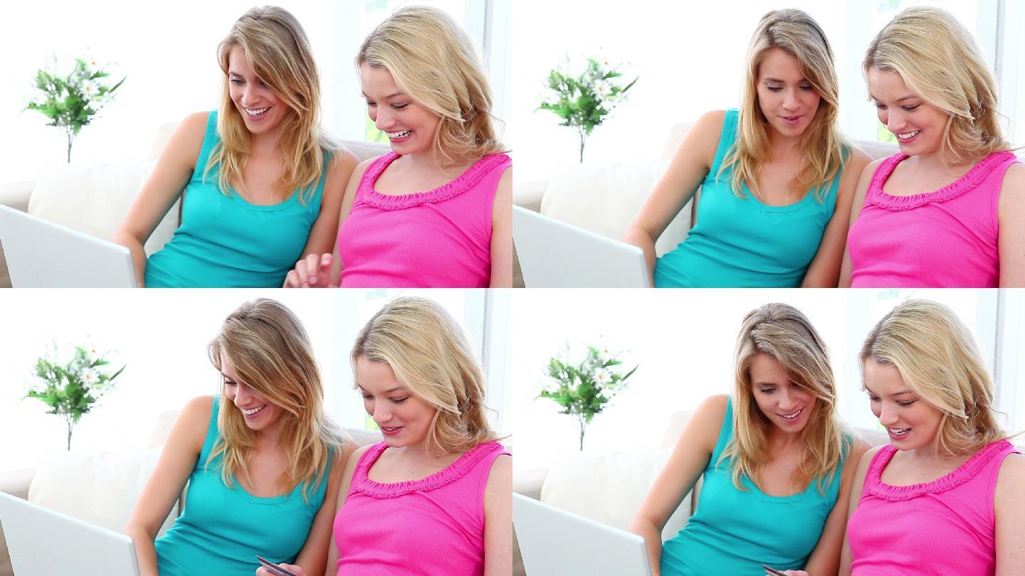 两个金发女人在笔记本电脑前