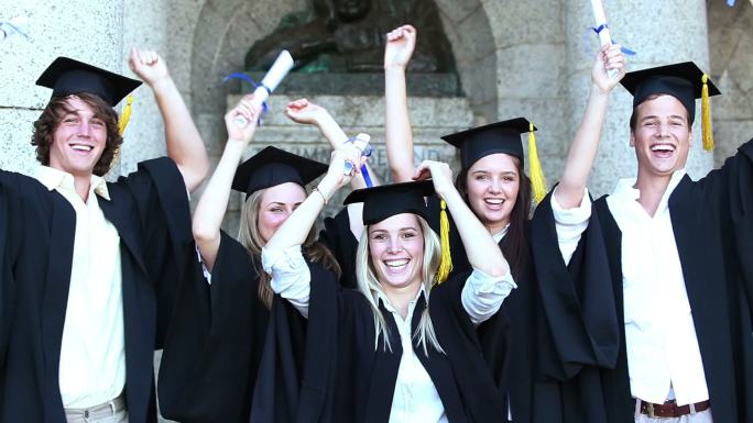 快乐的毕业生们举起手臂，欢呼雀跃