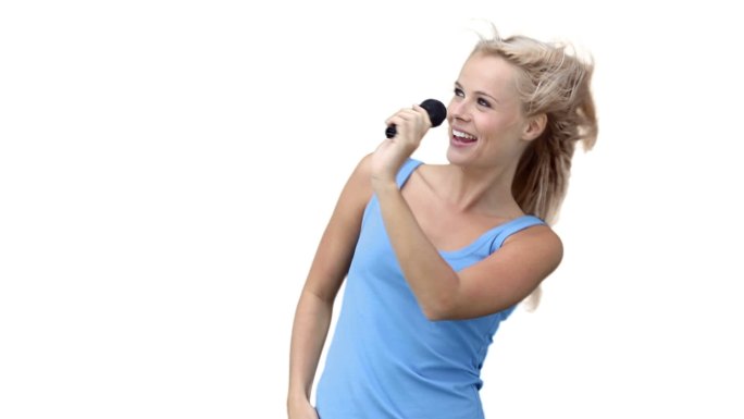 一个金发女人在白色背景下对着麦克风唱歌，跳舞