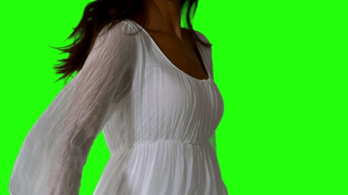穿着白色衣服的女孩在绿色屏幕上慢慢地靠近