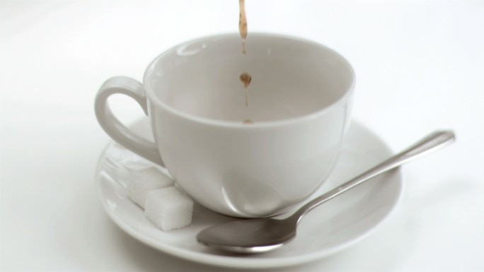 咖啡以晚餐的慢镜头落在白色背景下的杯子里