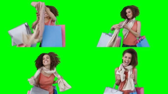 一个正在购物的女人在绿色背景下试穿她的围巾