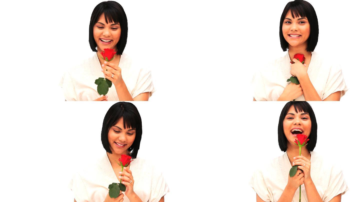 一个中国妇女拿着一朵孤立在白色背景上的红玫瑰