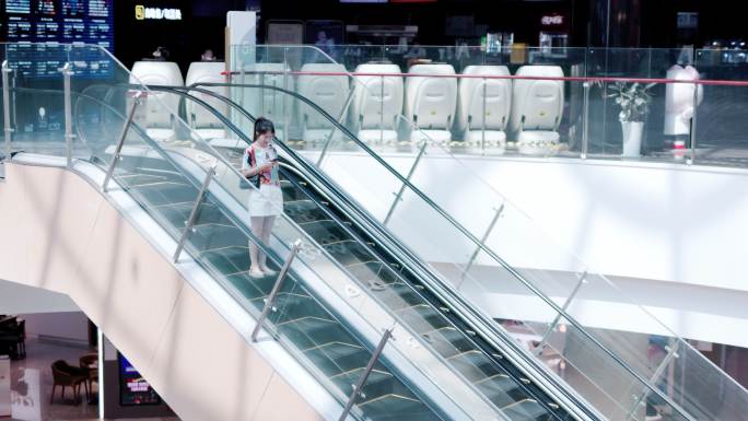 4K年轻女性在商场扶梯上使用手机