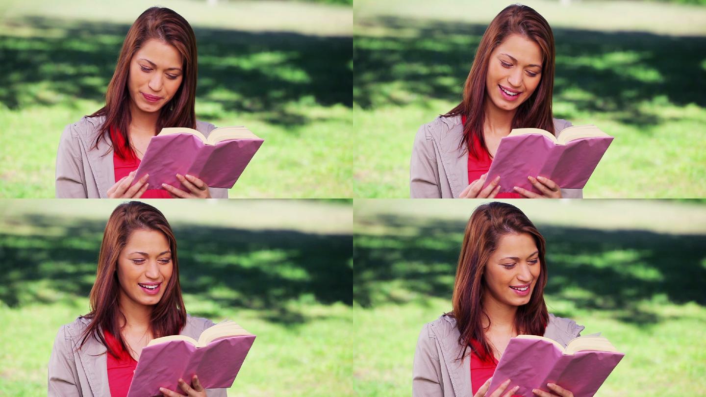 快乐的女人在乡下读一本有趣的小说