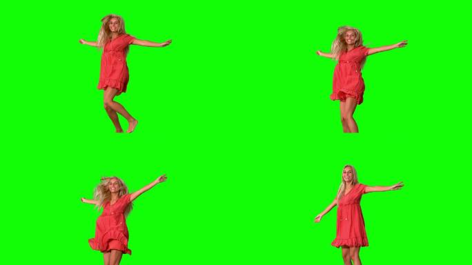 迷人的金发女郎在绿色屏幕上跳跃的慢动作