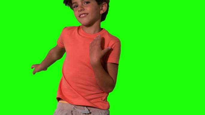 男孩跳跃在绿色屏幕上的特写慢动作