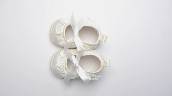 白色婴儿鞋在旋转白色表面