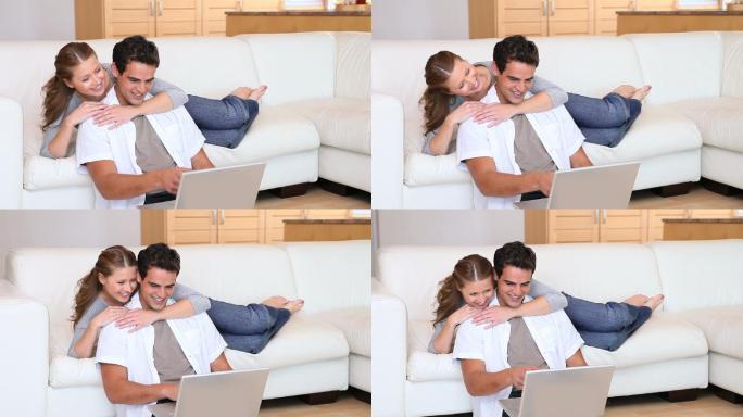 一个女人在客厅里用笔记本电脑拥抱她的男朋友