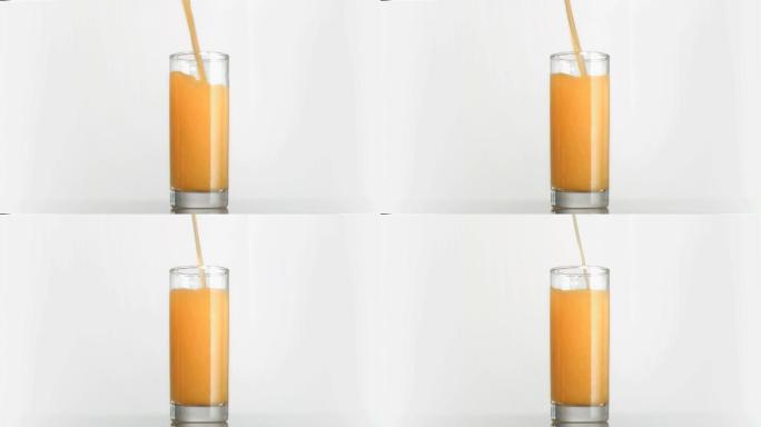 橙汁以超慢的动作流进白色背景的杯子里