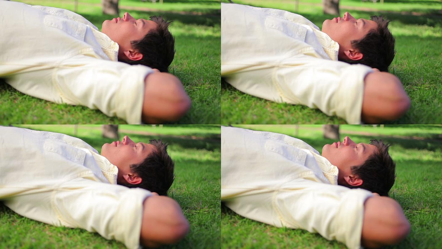 一个快乐的人躺在公园的草地上