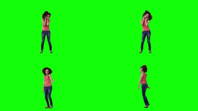 一个戴着耳机的女人在绿色背景下跳舞