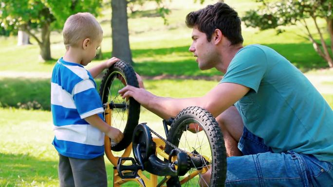 爸爸和儿子在公园里看自行车
