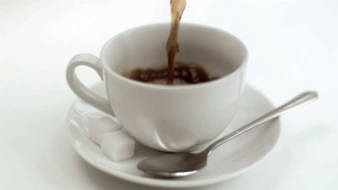 一杯咖啡在超级慢动作被填充在白色的背景