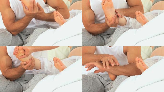一个男人正在给他怀孕的妻子做脚部按摩