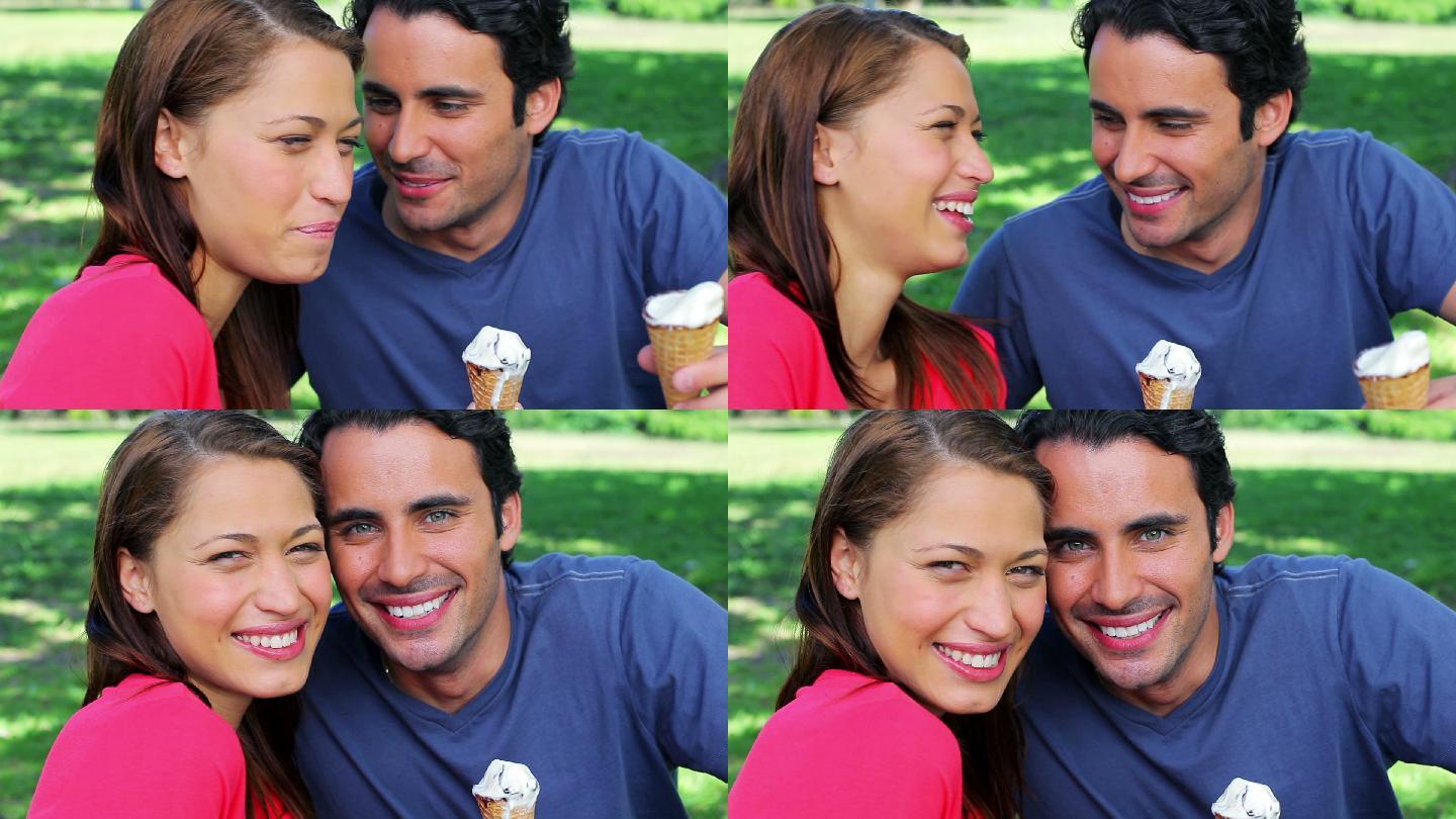 一对微笑的情侣在公园里吃甜筒