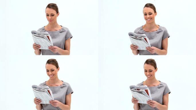一个微笑的女人拿着一本杂志，背景是白色的