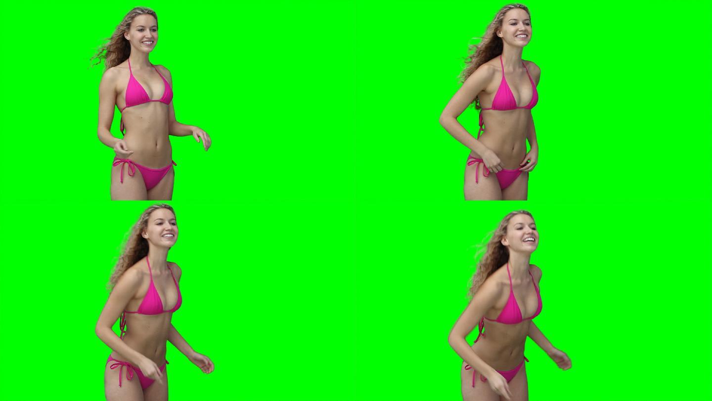 一个女人站在绿色的背景下微笑着玩飞盘