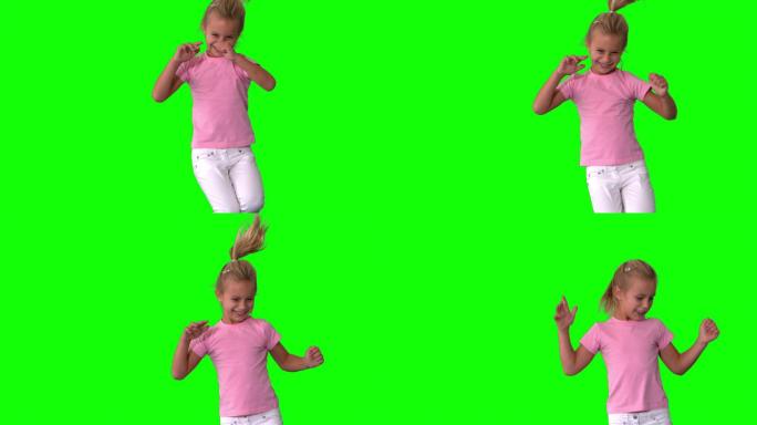 快乐的小女孩在绿色屏幕上跳跃的慢动作