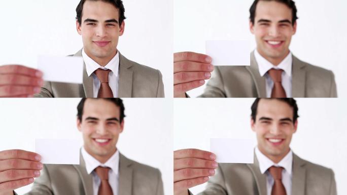 一个微笑的男人拿着一张白色背景的名片