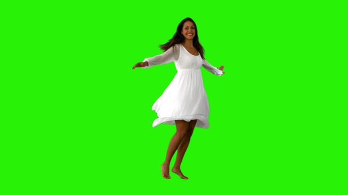 穿着白色裙子的女孩在绿色屏幕上慢动作地旋转